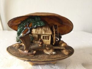 Miniatuur schelp met huis en rad en groene boom