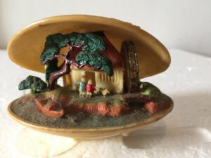 Miniatuur schelp huis met rad en plat bootje